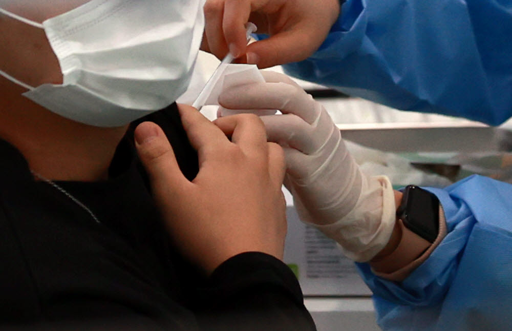 23일 오전 서울 관악구민종합체육센터에 마련된 신종 코로나바이러스 감염증(코로나19) 백신 접종센터를 찾은 시민이 백신 접종을 받고 있다. 연합뉴스