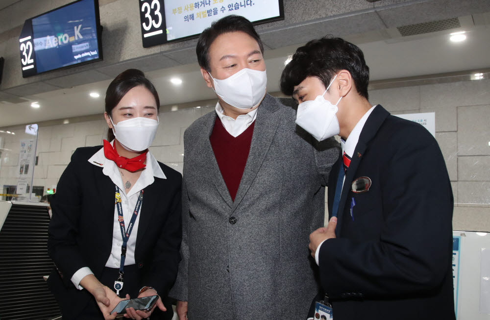 국민의힘 윤석열 대선 후보가 30일 오전 충북 청주시 청원구 청주국제공항을 방문해 한 항공사 직원들과 셀카를 촬영한 뒤 인사를 나누고 있다.