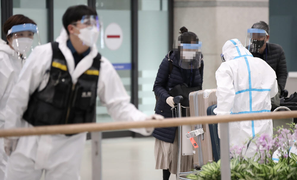 3일 오후 인천국제공항 제1여객터미널에서 한국과 아프리카 지역을 오가는 유일한 직항편인 에티오피아(아디스아바바)발 여객기 탑승자들이 입국장에서 방역관계자의 안내를 받고 있다. 연합뉴스