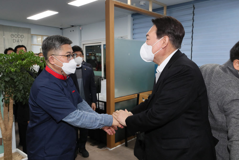 국민의힘 윤석열 대선 후보가 22일 저녁 전북 군산에서 횟집을 운영 중인 함운경 씨를 찾아 악수하고 있다. 함 씨는 지난 1985년 미국 문화원 점거 사건을 주도한 운동권 출신으로 언론을 통해 현 정부의 소득주도 성장 정책을 강하게 비판한 바 있다. 연합뉴스