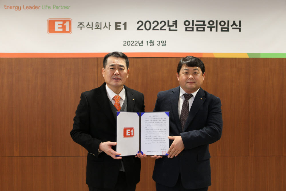 3일 서울 용산구 소재 E1 본사에서 구자용 E1 회장(왼쪽)과 박승규 E1 노조위원장이 2022년도 임금에 관한 위임장을 들고 기념 촬영하고 있다. [사진= E1 제공]