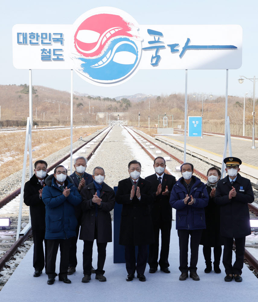 문재인 대통령이 5일 오전 강원 고성군 제진역에서 열린 동해선 강릉~제진 철도건설 착공식이 끝난 뒤 서명판에 서명한 뒤 참석자들과 기념촬영을 하고 있다. 연합뉴스