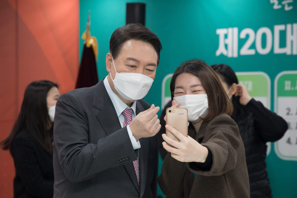 윤석열 국민의힘 대선후보가 18일 서울 영등포구 사회복지사협회에서 간담회를 마치고 한 참석자의 셀카를 찍고 있다. <국회사진기자단>