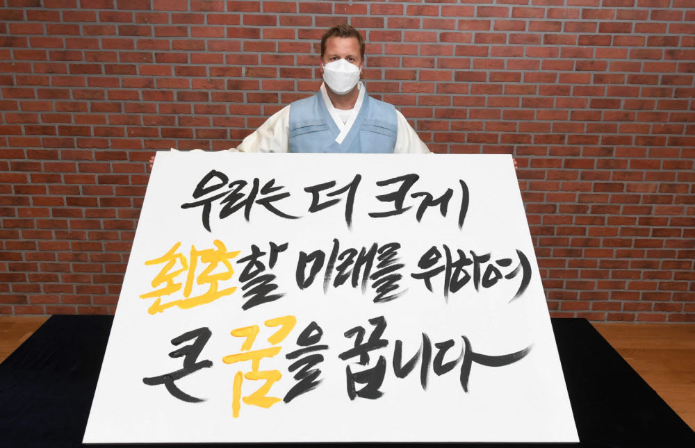 26일 오비맥주 배하준 대표가 새로운 기업 슬로건을 공개하는 선포식에서 새 슬로건 캘리그래피 작품을 들고 기념 촬영을 하고 있다.