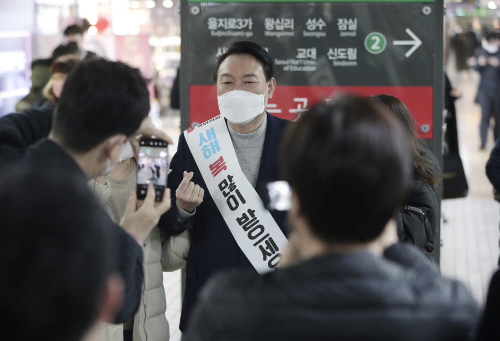 윤석열 국민의힘 대선후보가 설 연휴 첫날인 29일 서울 강남역을 찾아 시민들에게 새해 인사를 하며 기념촬영을 하고 있다.