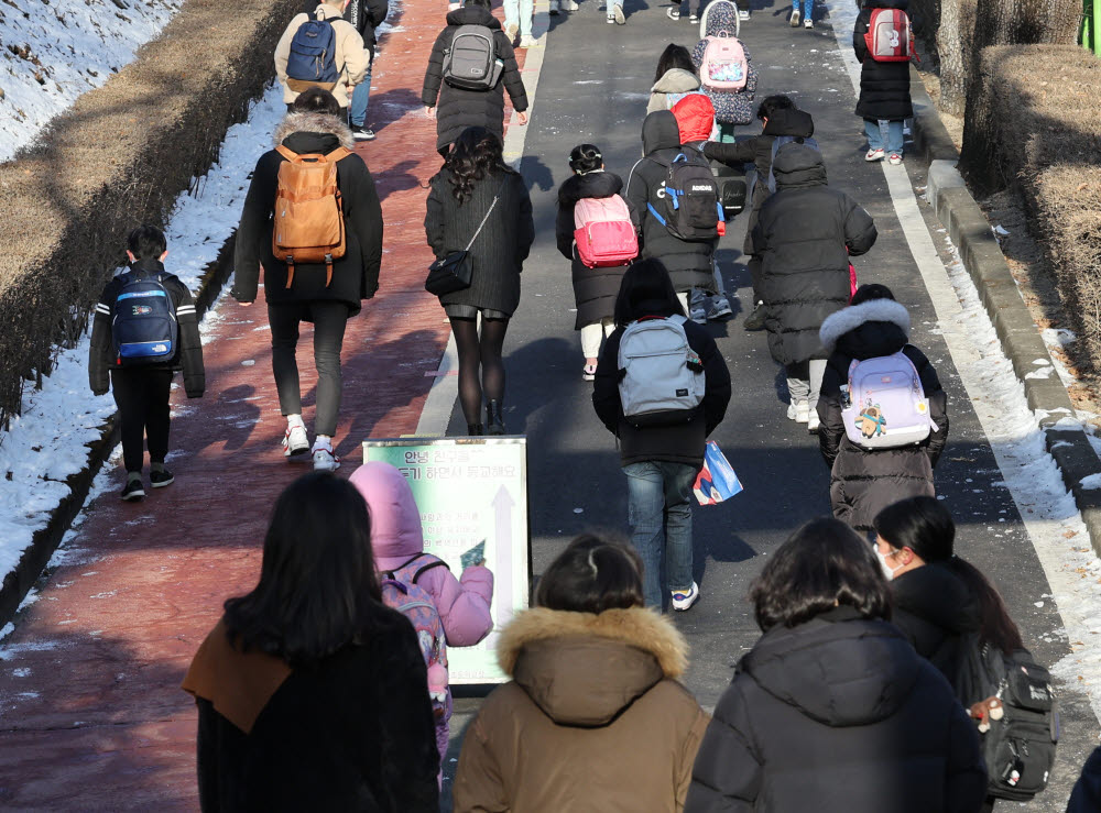 (서울=연합뉴스) 한상균 기자 = 7일 오전 서울 한 초등학교에서 학부모들이 아이들 등교 모습을 보고 있다. 교육부는 이날 2022학년도 학사 운영 방안을 발표할 예정이다. 등교 수업을 원칙으로 하지만, 오미크론 변이의 확산 상황에 따라 각 시도교육청과 학교의 자율성을 강화하는 방안이 발표될 것으로 보인다. 신속항원검사 활용 등 학교 내 진단 검사 체계도 바뀔 전망이다. 2022.2.7
 xyz@yna.co.kr