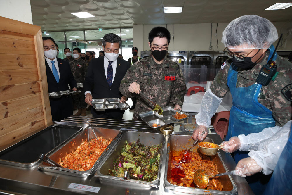 7일 충남 논산시 육군훈련소 28연대 식당에서 문승욱 산업통상자원부 장관(왼쪽)과 서욱 국방부 장관이 로봇을 활용해 조리한 급식 메뉴를 배식받고 있다.