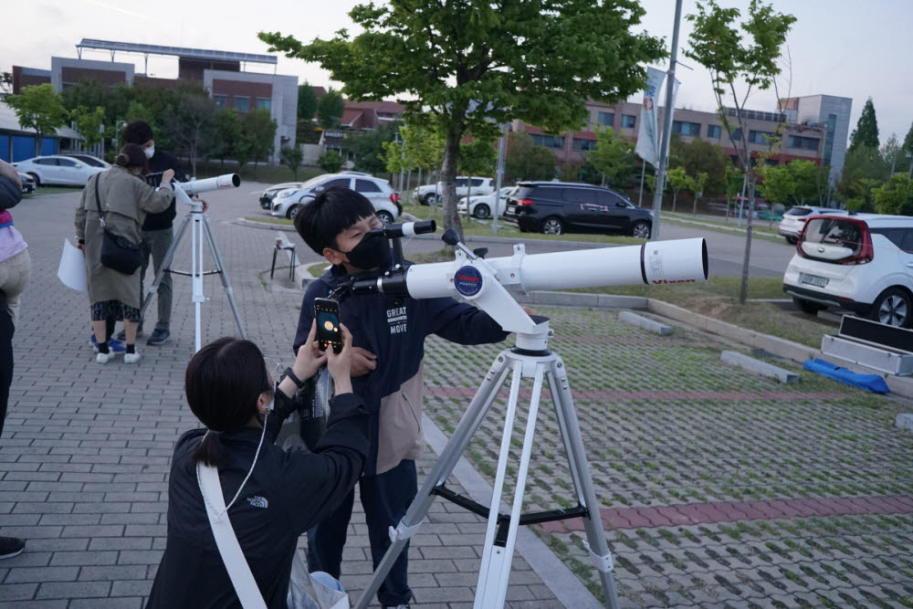 망원경을 통해 천체관측 중인 관람객.