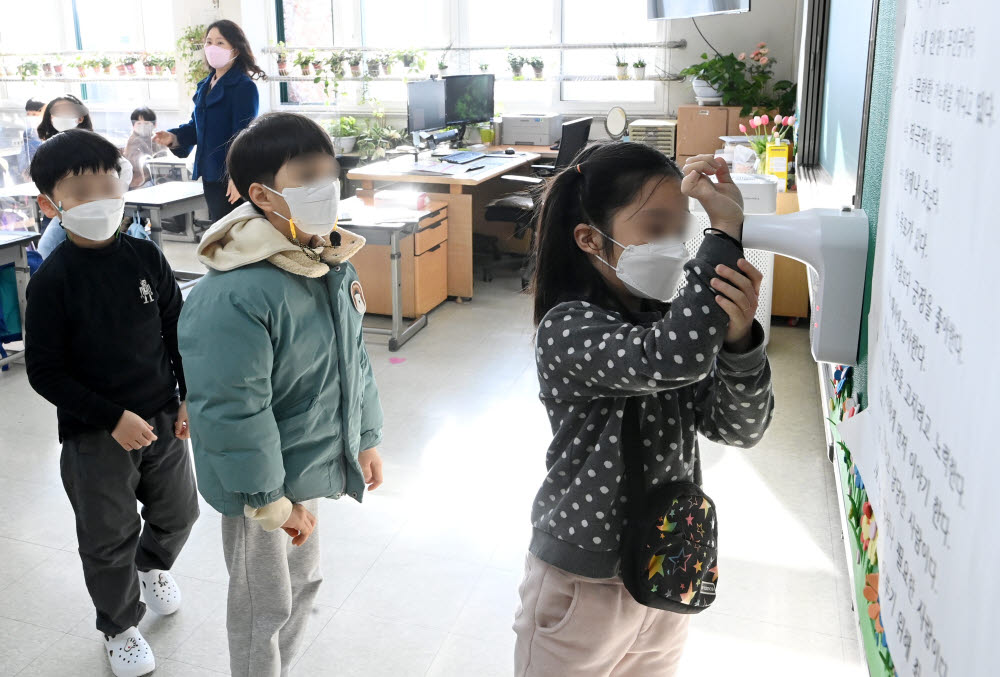 2022학년도 새학기 첫 날인 2일 서울 노원구 태랑초등학교에서 수업 전 체온을 체크하고 있다. 코로나19 오미크론 변이가 정점으로 향하고 있는 가운데 교육부는 정상등교 원칙을 유지하되 확진자가 많아 감염이 우려되는 지역의 학교들은 수업시간 단축이나 밀집도 조정, 원격수업 등을 탄력적으로 결정할 수 있다. 이동근기자 foto@etnews.com