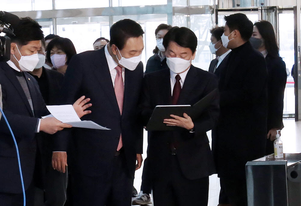 윤석열 국민의힘 대선후보(왼쪽)와 안철수 국민의당 대선 후보가 단일화 기자회견에 앞서 대화하고 있다.