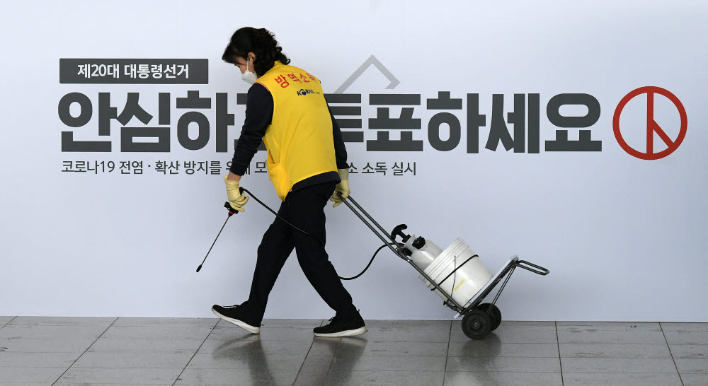 제20대 대통령선거 사전투표일인 4일 서울 용산구 서울역에 마련된 남영동 사전투표소에서 서울역 관계자가 소독을 하고 있다.