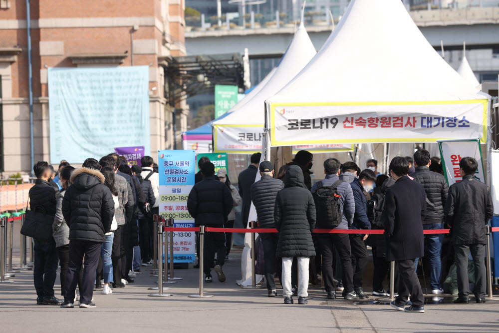 21일 오전 서울역 선별진료소에서 시민들이 신속항원검사 결과를 기다리고 있다. 중앙방역대책본부는 21일 0시 기준 코로나19 신규 확진자가 20만9169명 집계됐다고 밝혔다. 연합뉴스