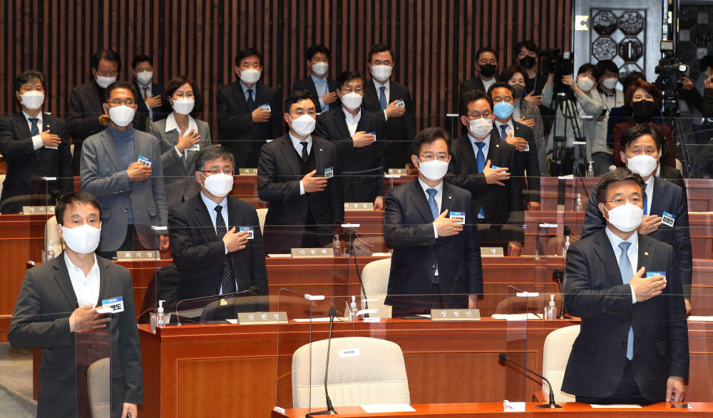 더불어민주당 윤호중 공동비상대책위원장과 참석 의원들이 24일 오후 서울 여의도 국회에서 열린 민주당 제3기 원내대표 선출을 위한 의원총회에서 국민의례를 하고 있다.