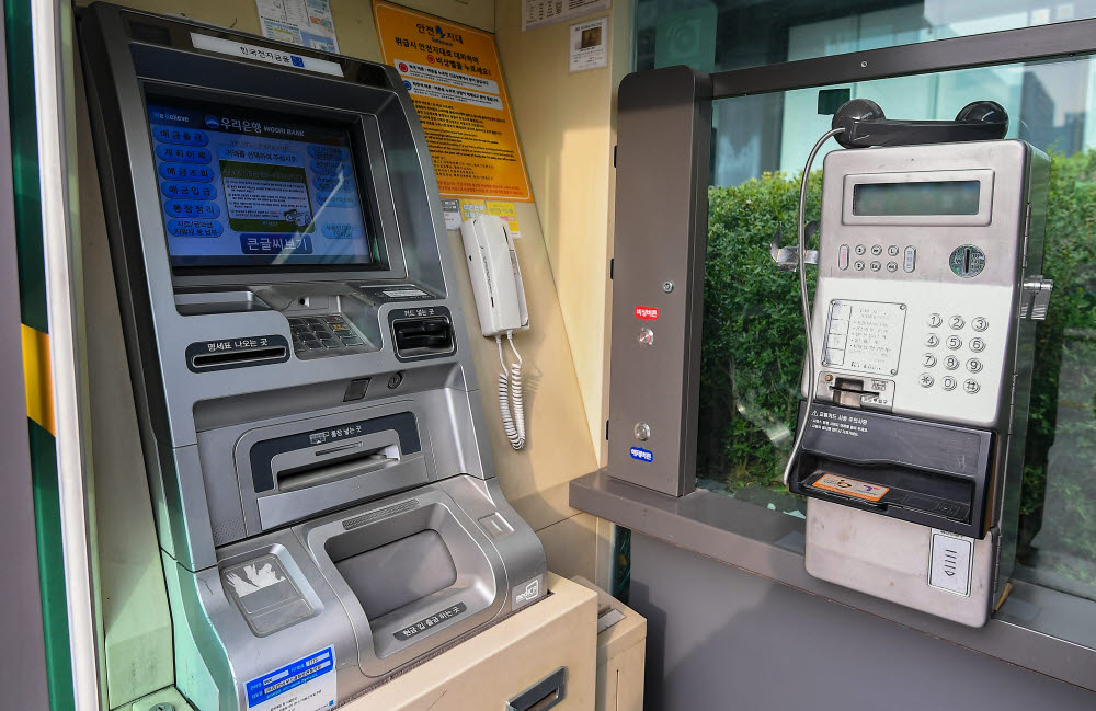 ATM기와 결합된 멀티부스. 전화기 위에 올라있는 수화기가 과거를 추억하게 된다.