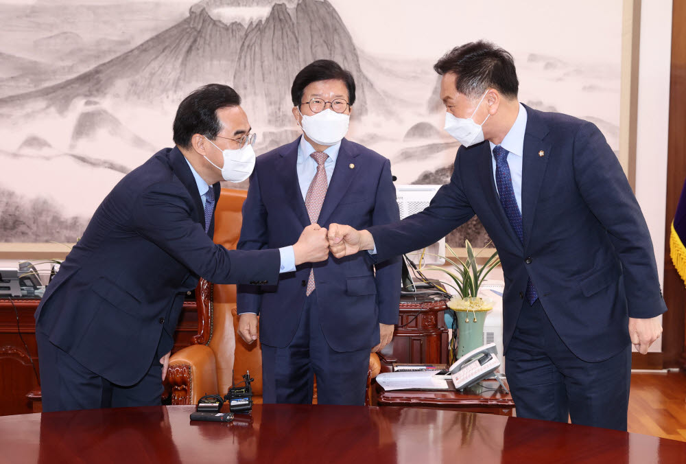 30일 오전 국회에서 박병석 국회의장 주재로 열린 양당 원내대표 회동에서 박홍근 더불어민주당 원내대표와 김기현 국민의힘 원내대표가 주먹 인사를 하고 있다.