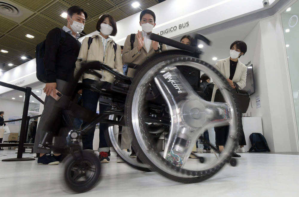 참관객들이 KT디지코시티에서 AIoT 휠체어를 살펴보고 있다.
