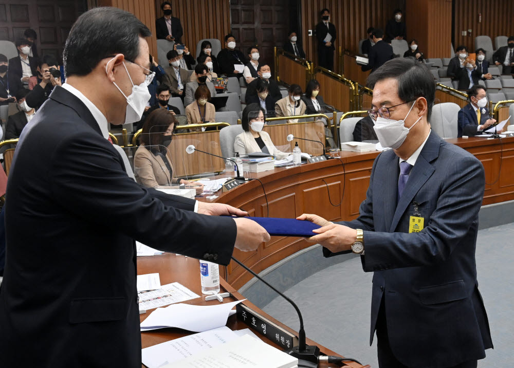 한덕수 국무총리 후보자가 주호영 위원장에게 선서문을 전달하고 있다. <공동취재>