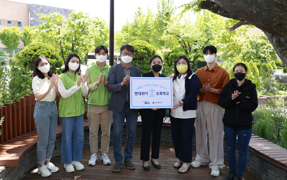 현대위아 임직원과 국립서울농학교 학생, 교사들이 11일 서울 종로구 국립서울농학교 내 현대위아가 조성한 느티나무 정원에서 기념촬영했다.