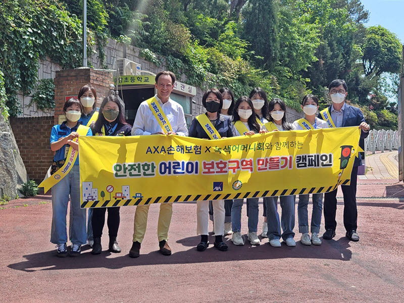 기욤 미라보 악사손보 대표이사(앞줄 왼쪽 세번째)를 비롯한 임직원이 지난 12일 서울 용산구 소재 후암초등학교 앞에서 후암초 학교장 및 녹색어머니회가 함께한 가운데 안전한 어린이 보호구역 만들기 캠페인을 실시했다.