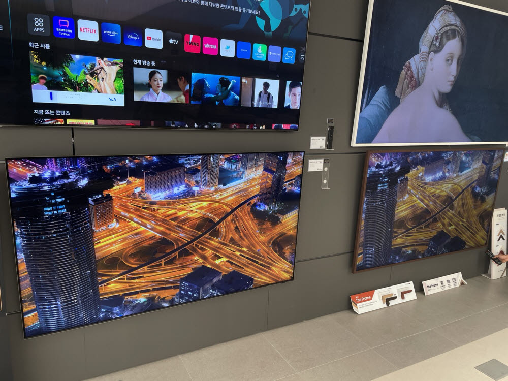 삼성 디지털프라자 영통본점 내 TV 전시존에서 네오 QLED 8K(왼쪽 아래)와 네오 QLED 4K(오른쪽) 제품을 나란히 비치한 뒤 동일 콘텐츠의 화질 차이를 고객에게 소개하고 있다.