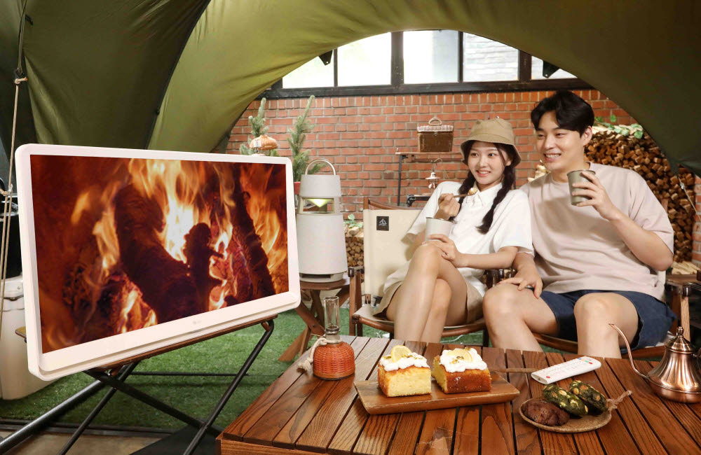 LG전자 모델들이 서울시 강남구에 위치한 캠핑 카페 글락에서 LG 룸앤TV 신제품으로 콘텐츠를 감상하고 있다. [자료:LG전자]