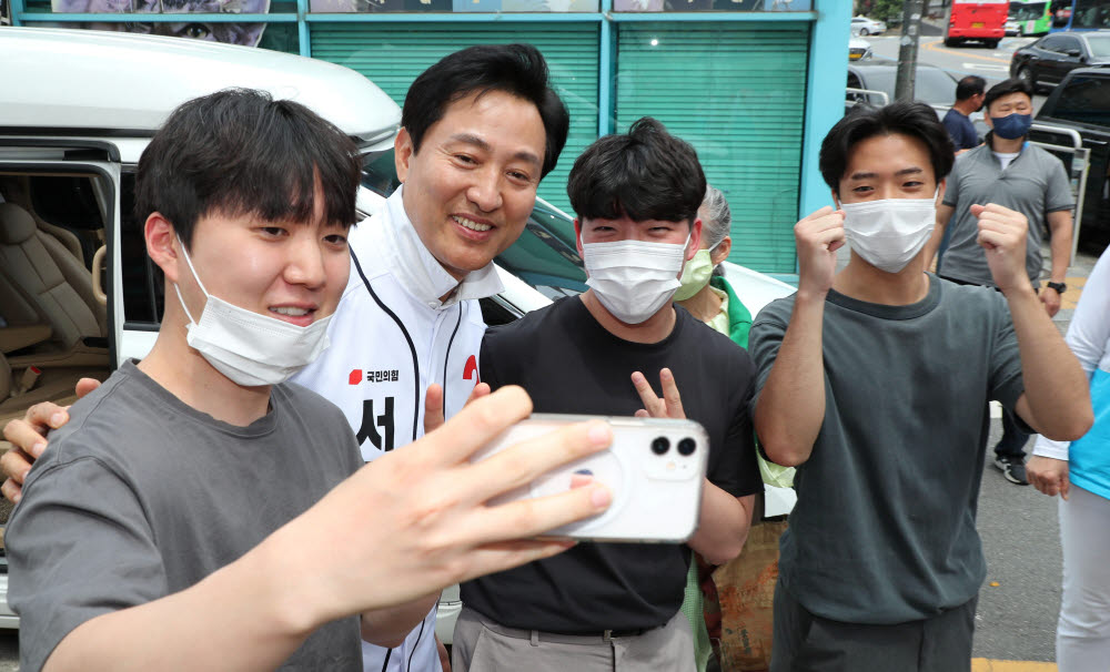 오세훈 국민의힘 서울시장 후보가 29일 서울 마포구 연남동 경의선숲길을 돌며 시민들과 기념촬영하고 있다. 연합뉴스