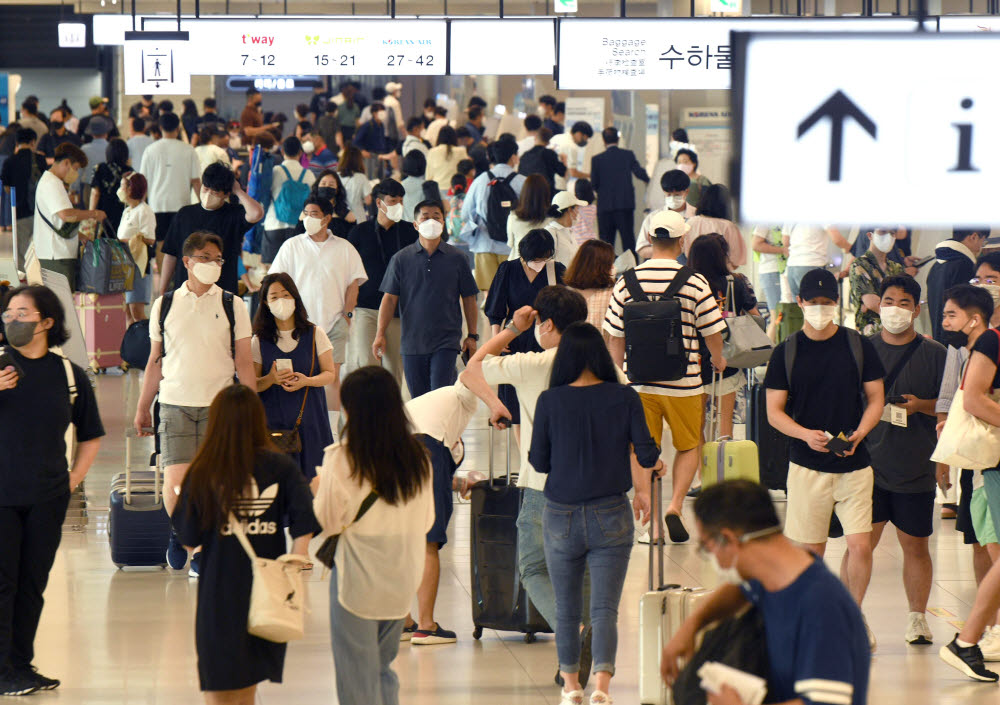 코로나19 유행이 재확산세를 보이는 가운데 지난 9일 서울 김포공항에서 여행객들이 발걸음을 옮기고 있는 모습. 김민수기자 mskim@etnews.com