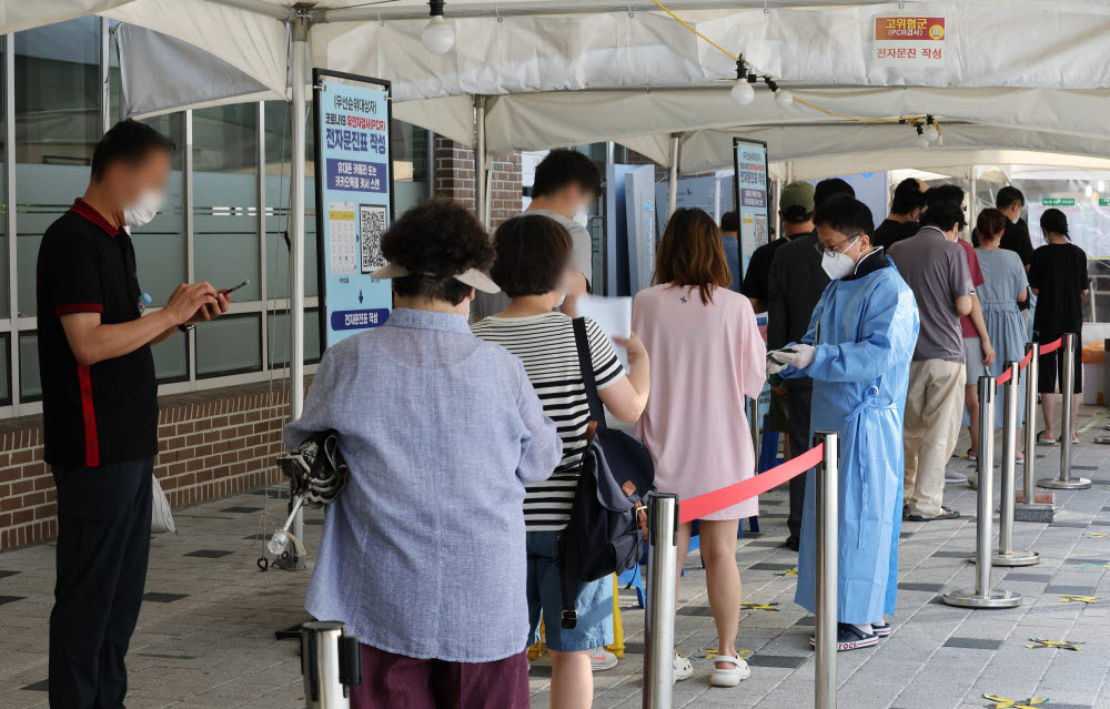 코로나19 신규확진자가 9만9327명으로 다시 10만명에 근접한 26일 오전 서울 마포구보건소 코로나19 선별진료소에서 검사를 받으려는 시민들이 줄을 서고 있다. 연합뉴스