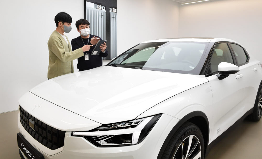폴스타 데스티네이션 서울 스페셜리스트가 고객에게 폴스타2 차량 설명을 하고 있다.