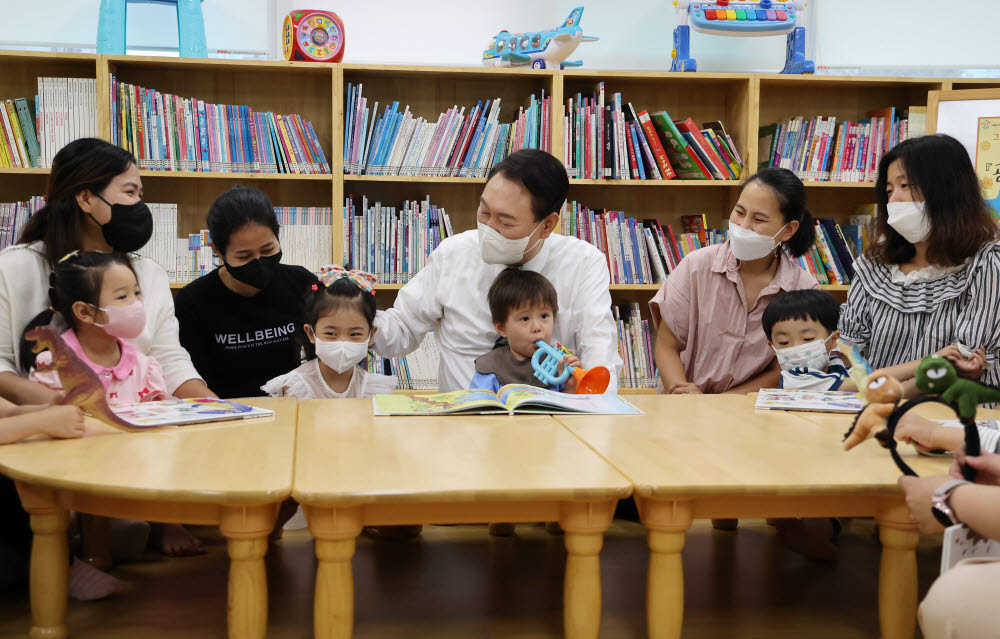 윤석열 대통령이 30일 오전 서울 구로구 가족센터를 방문, 공동육아나눔터에서 공동 육아에 대한 설명을 들은 후 아이들과 함께 그림동화책을 보며 대화하고 있다. 연합뉴스