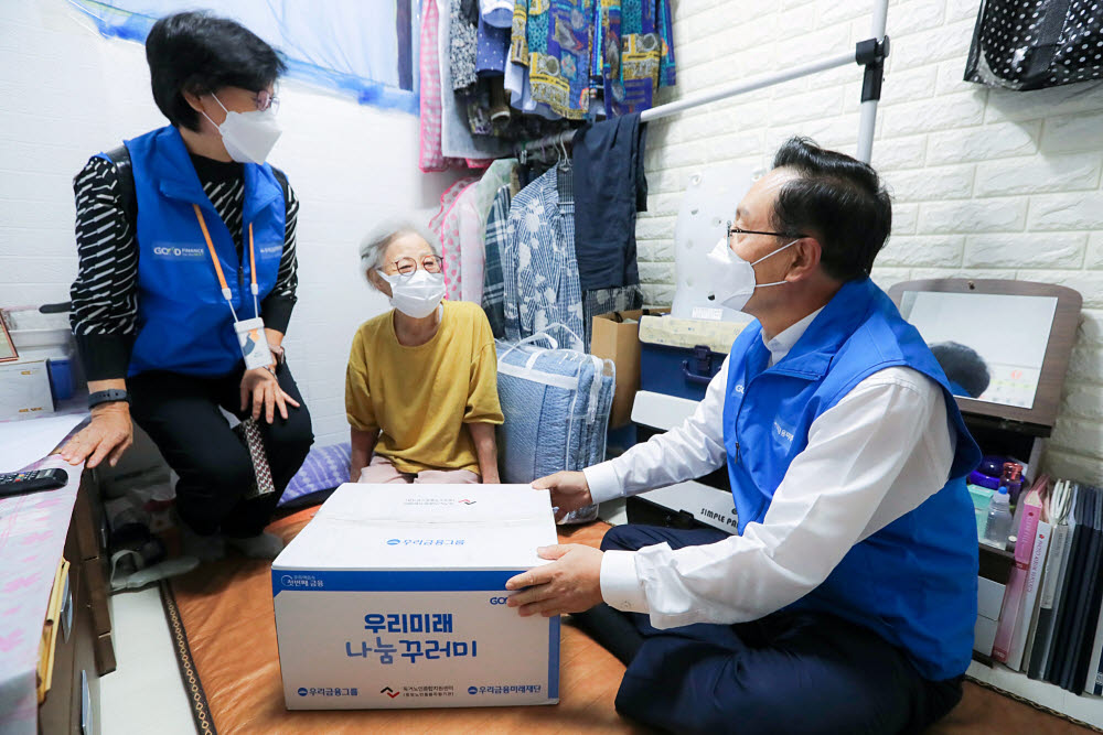 우리금융그룹 우리금융미래재단이 7일 서울 종로구 창신동 소재 쪽방 상담소에서 추석맞이 우리미래 나눔꾸러미 전달식을 가졌다. 손태승 이사장(오른쪽)이 우리미래 나눔꾸러미를 전달했다.