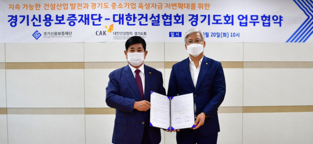 이민우 경기신용보증재단 이사장(오른쪽)이 지난 20일 대한건설협회 경기도회와 경기도 탄소중립 실현 및 도내 중소건설업 경쟁력 강화를 위해 업무협약을 체결한 뒤 기념촬영을 하고 있다.