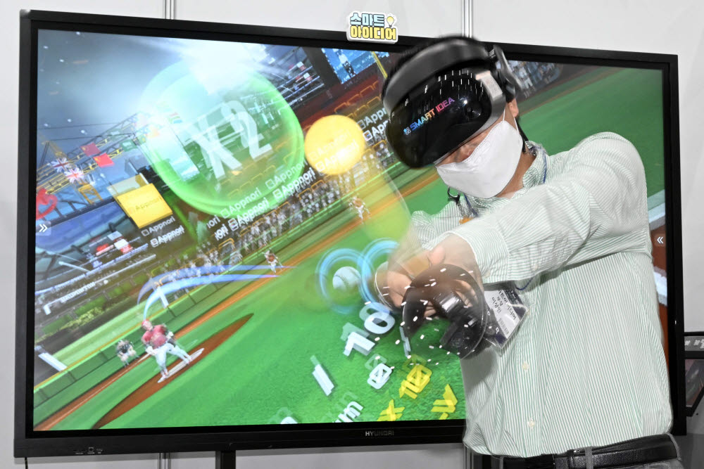 스마트교육학회 실내스포츠 공동관에서 관계자가 VR콘텐츠를 이용한 야구 게임을 시연하고 있다.