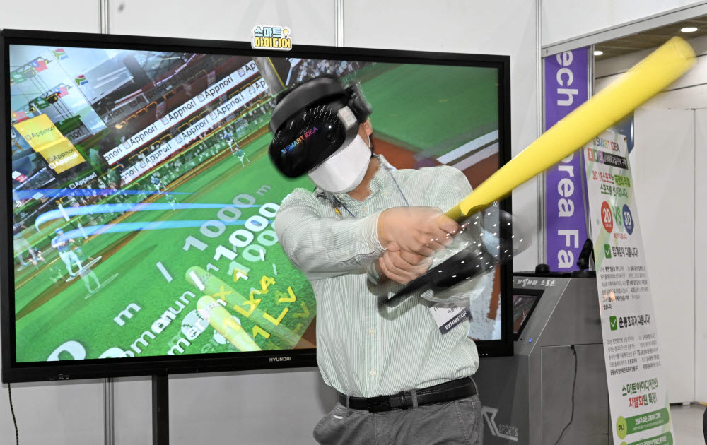 스마트교육학회 실내스포츠 공동관에서 관계자가 VR콘텐츠를 이용한 야구 게임을 시연하고 있다.
