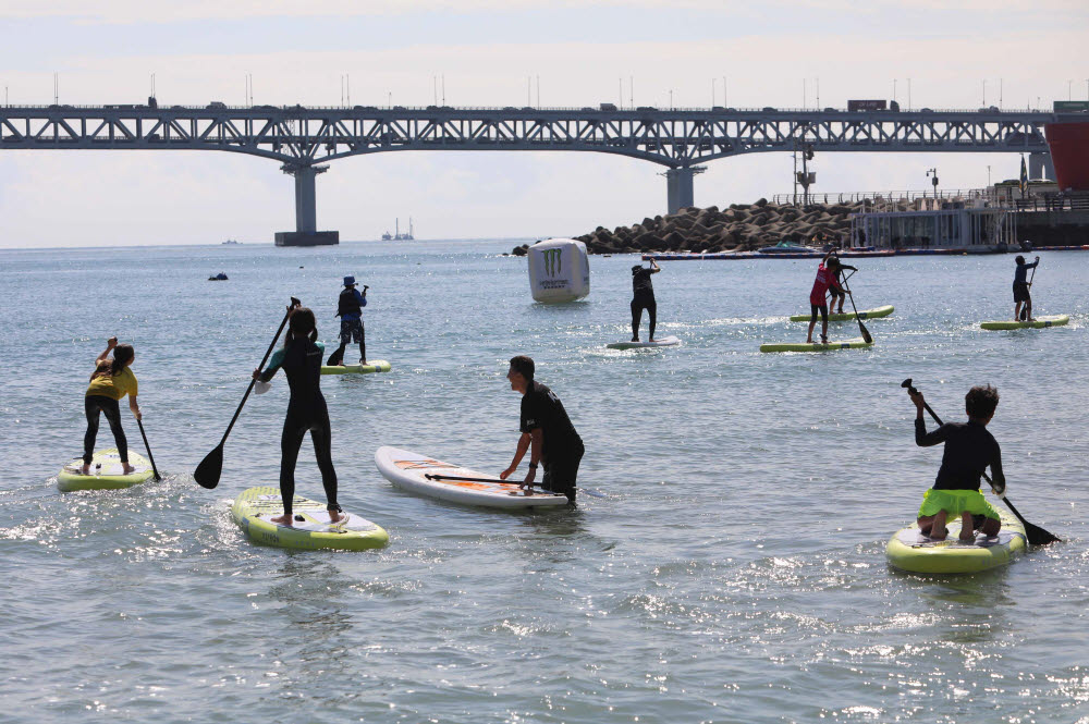 23일 부산 광안리 해변에서 열린 2022 APP WORLD TOUR BUSAN SUP OPEN(월드투어 부산 썹 오픈) 대회 참가자들이 경기에 앞서 바다에서 연습을 하고 있다. 사진제공=KAPP(대한패들서프 프로협회)