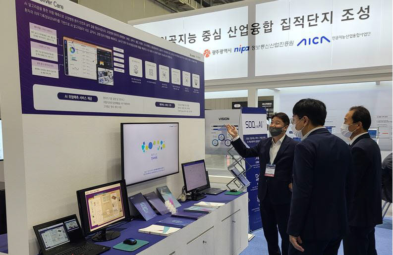 국내 최대 규모 인공지능산업 전시회 AI TECH+ 2022 전시회 비투엔 부스에서 비투엔 관계자가 참관객에게 서비스를 소개하고 있다.