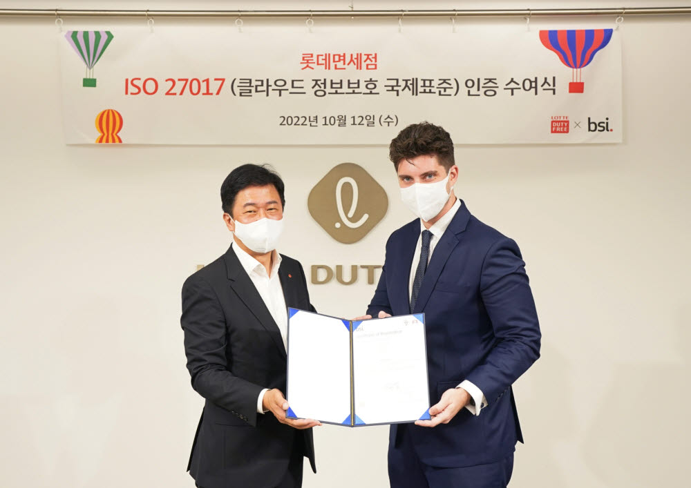 12일 서울 중구 롯데면세점 본사에서 열린 ISO 27017 인증 수여식에서 이갑 롯데면세점 대표(왼쪽)와 톰 헬름 주한 영국대사관 서기관이 기념촬영을 하고 있다.