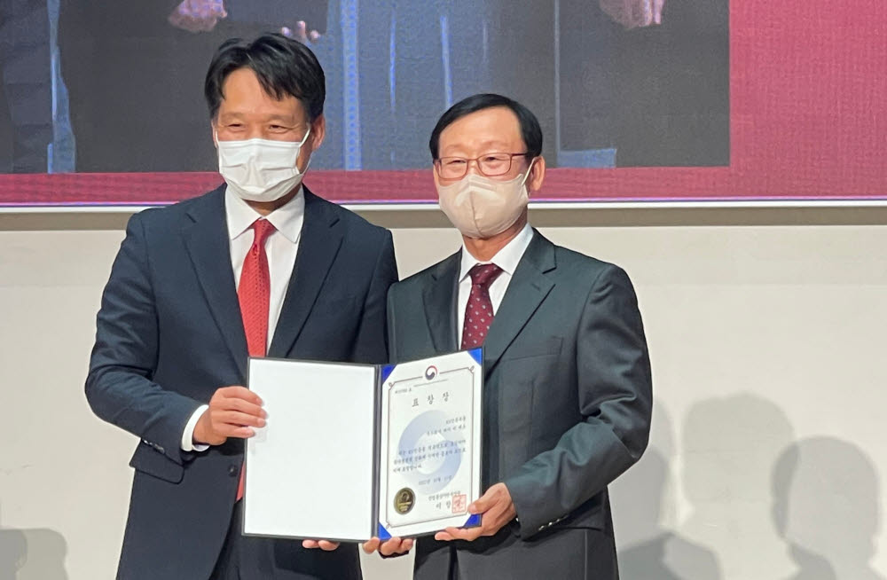 김영래 대표(오른쪽)가 2022 세계 표준의 날 기념식에서 이상훈 국가기술표준원 원장으로부터 표창을 수상하고 있다.