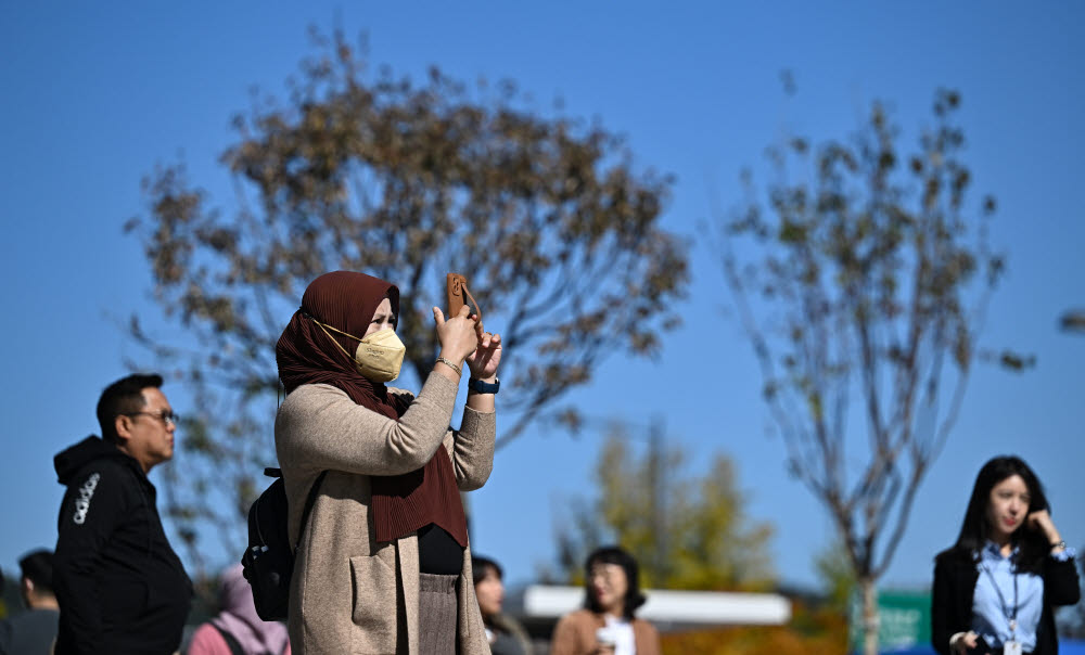 한 외국인 관광객이 서울의 가을을 스마트폰에 담고 있다.