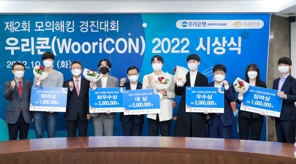 우리은행이 지난 18일 우리은행 본점에서 개최한 제2회 모의해킹 경진대회 우리콘(WooriCON) 시상식에서 이원덕 우리은행장(왼쪽 다섯번째), 김철웅 금융보안원장(왼쪽 세번째), 김백수 우리은행 정보보호그룹 부행장(오른쪽 세번째), 박춘식 아주대학교 교수(왼쪽 첫번째), 박찬암 스틸리언 대표(오른쪽 첫번째)가 수상자들과 기념촬영했다.