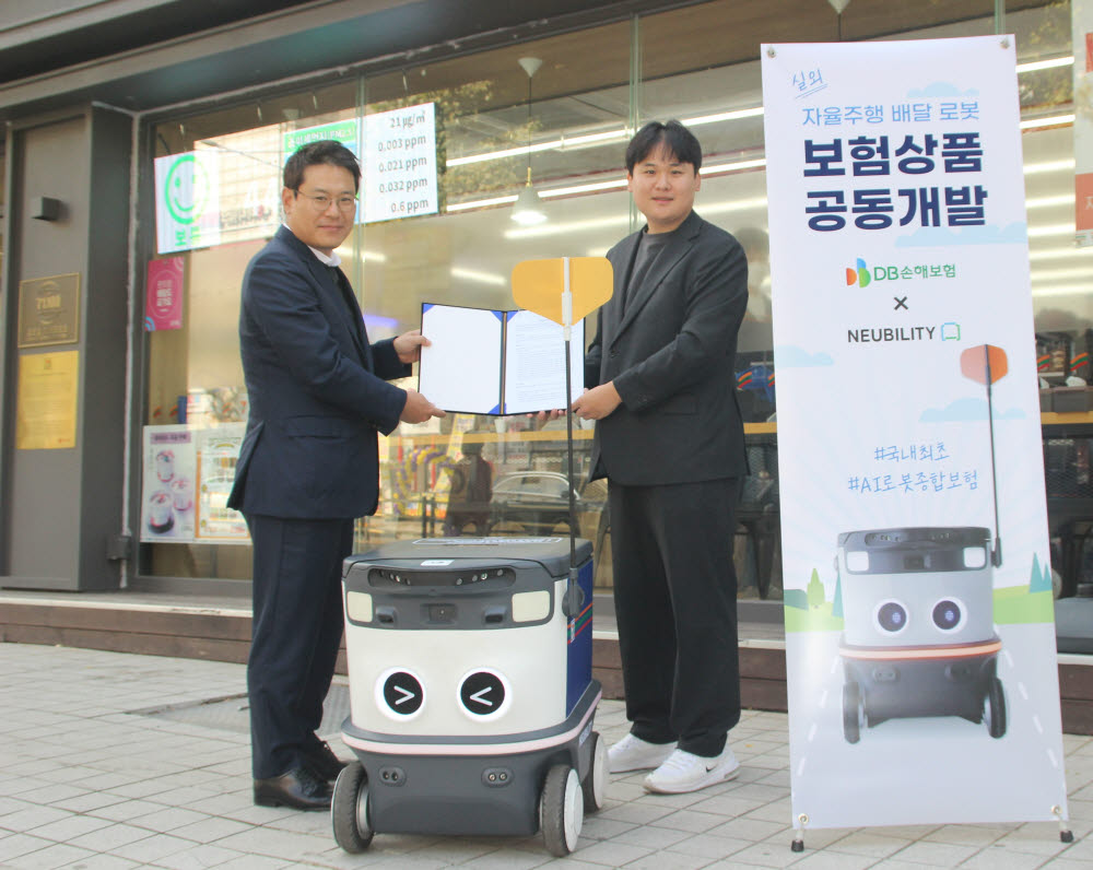 이상민 뉴빌리티 대표(오른쪽)가 뉴빌리티 실외 로봇이 운행 중인 서울 방배동 편의점 현장에서 김병은 DB손해보험 상무와 업무협약을 체결한 뒤 기념촬영을 하고 있다.(뉴빌리티 제공)