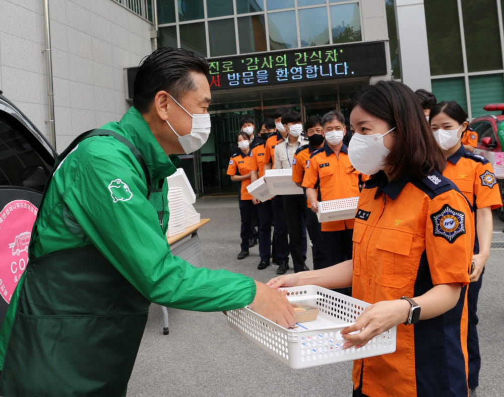 김인규 하이트진로 대표가 감사의 간식차 행사에서 간식을 나눠주고 있다.