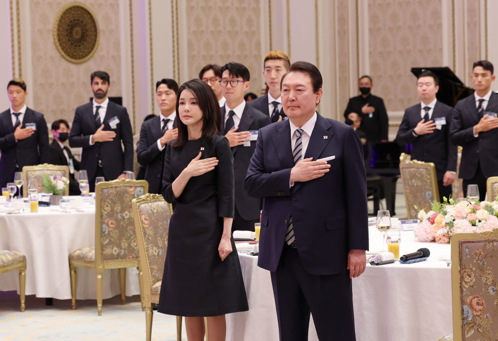 윤석열 대통령과 김건희 여사가 8일 청와대 영빈관에서 열린 축구 국가대표팀 환영 만찬에서 축구대표팀과 함께 국기에 경례를 하고 있다. 연합뉴스