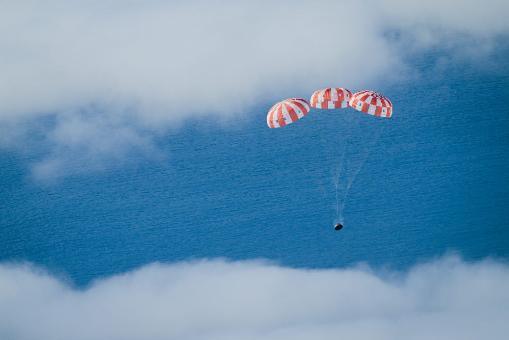 달 왕복 비행을 마친 오리온 우주선이 낙하산을 펴고 태평양에 착수하고 있다. (출처: NASA)