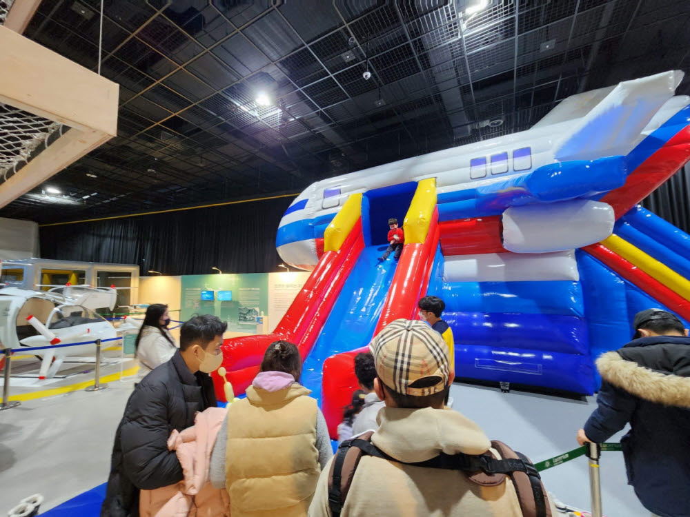 비행기 비상탈출을 체험하는 관람객 모습.