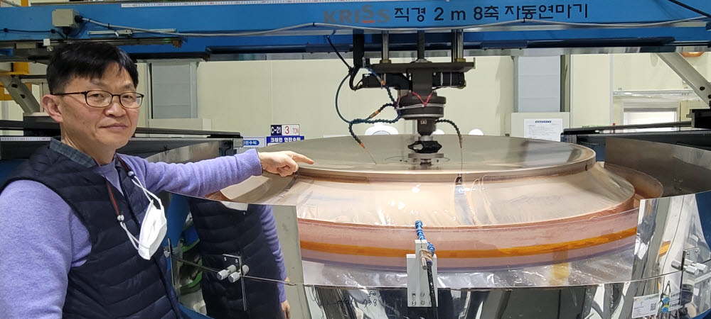 Yang Ho-sun, pesquisador sênior da equipe Aerospace Optics no Korea Standards Institute, explica o espelho óptico de 1,6 metros de diâmetro que está sendo fabricado atualmente.