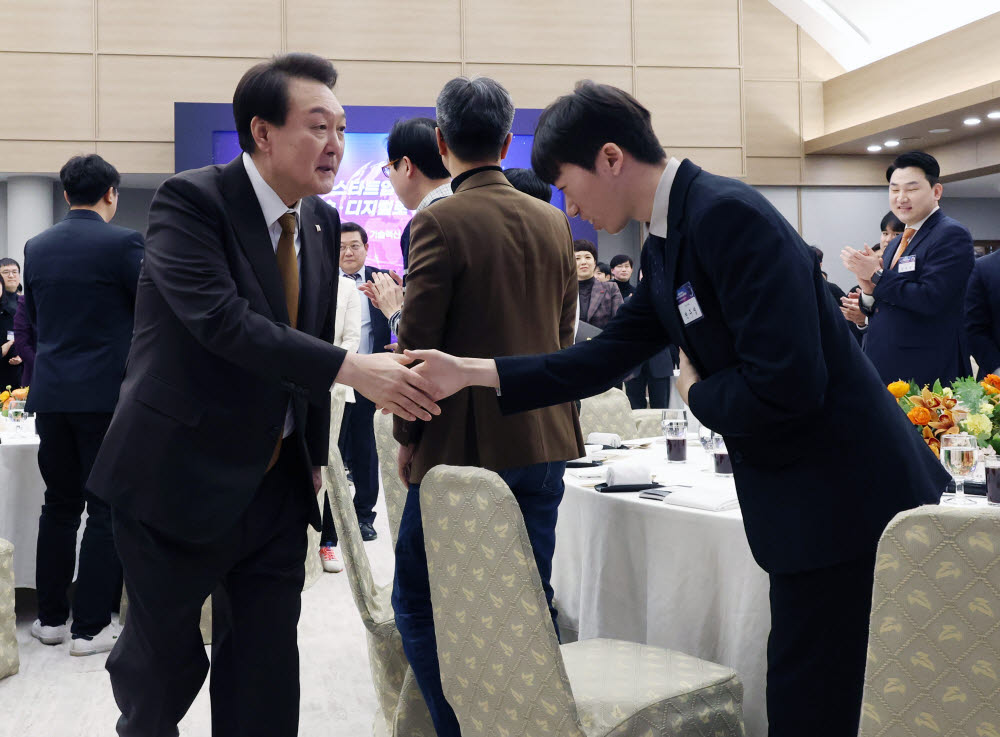 윤석열 대통령이 2일 서울 용산 대통령실 청사에서 열린 국제전자제품박람회(CES) 디지털 기술혁신 기업인과의 오찬 간담회에 입장하며 참석자들과 인사를 나누고 있다.