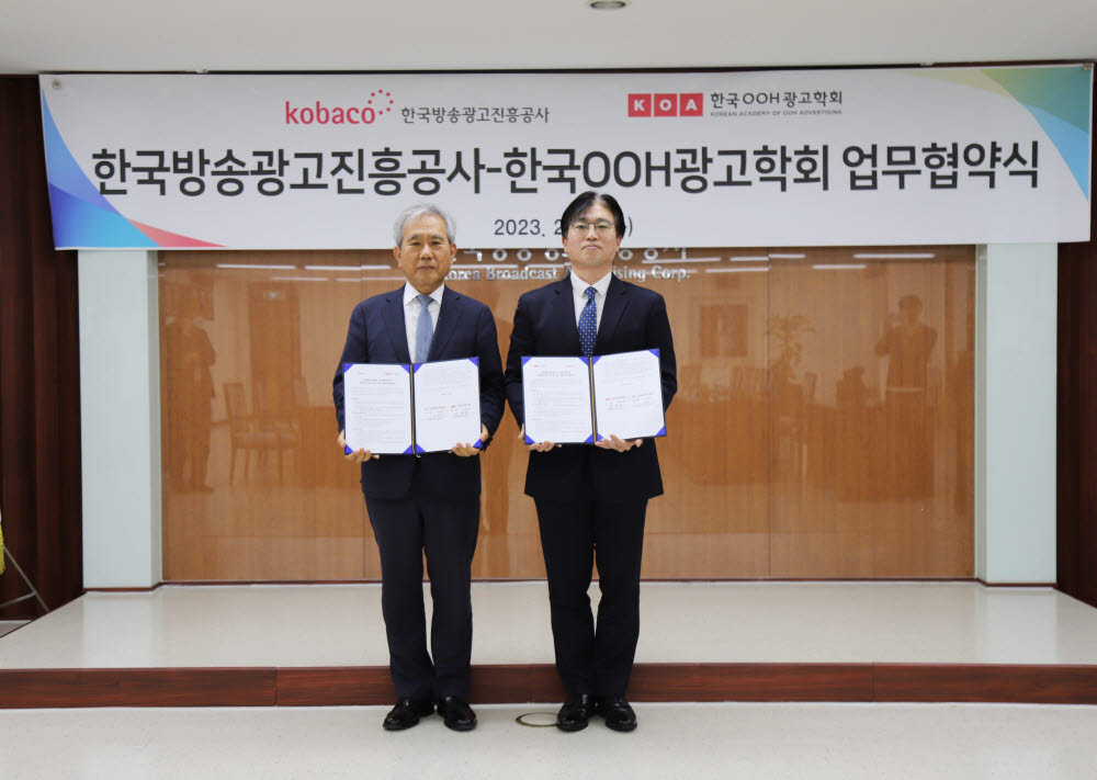 이백만 한국방송광고진흥공사 사장(왼쪽)과 유현중 한국OOH광고학회장이 업무협약을 체결하고 사진촬영을 하고 있다.