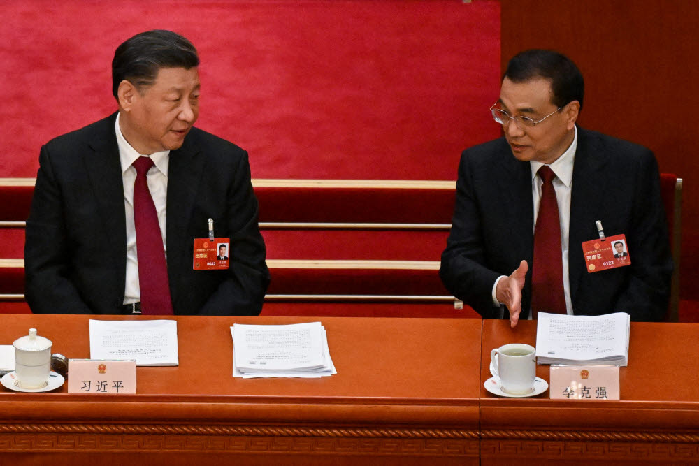 5일 중국 베이징 인민대회당에서 열린 전국인민대표대회 연례회의에서 시진핑 국가주석(왼쪽)과 리커창 총리가 대화하고 있다. <AFP>