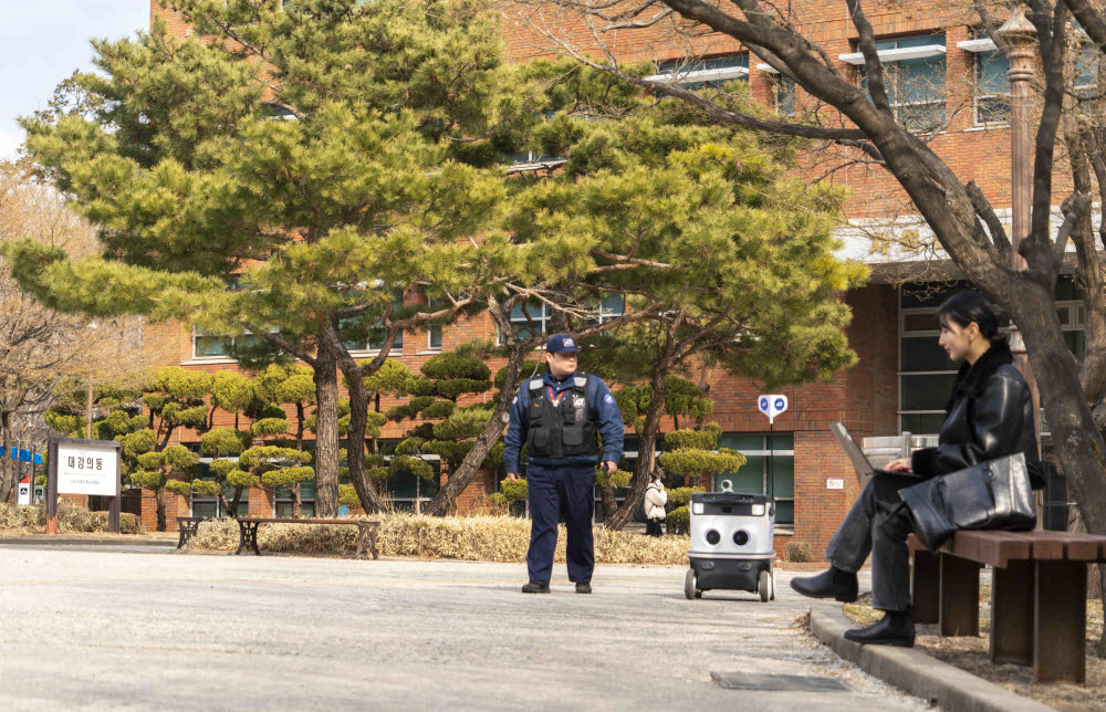 SK텔레콤 관계자가 AI순찰로봇을 덕성여대에서 테스트하고 있다.